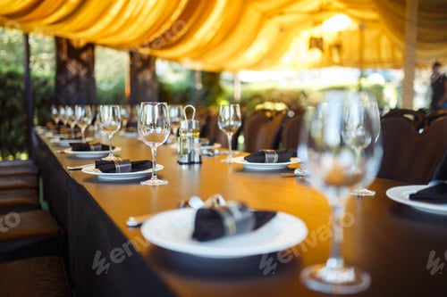 Preview: Sparkling glassware stands on long table prepared for wedding dinner.