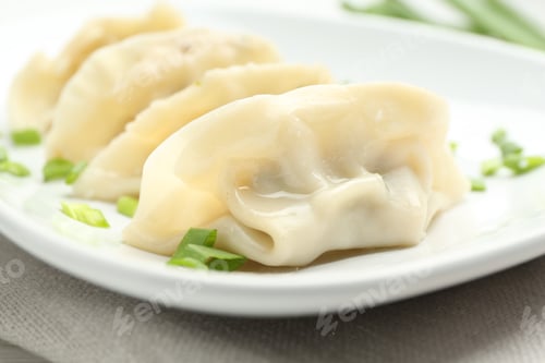 Preview: Tasty boiled gyoza (dumplings) with green onion on table, closeup