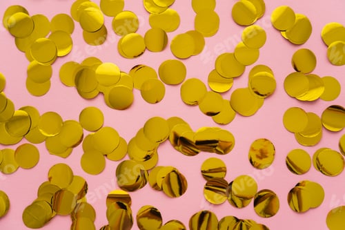 Preview: Top view of golden confetti on pink background