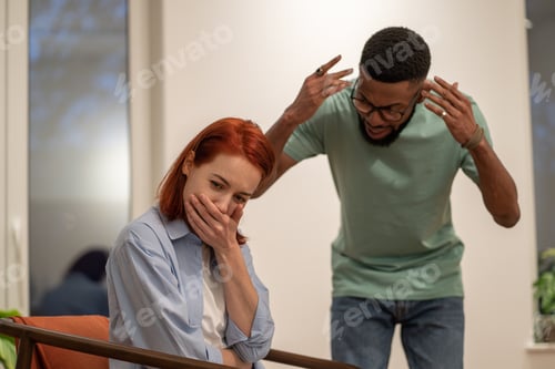 Preview: Mad angry African American man husband blaming and shaming wife at home. Domestic violence concept