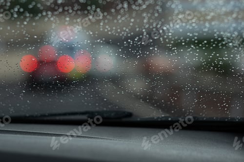 Preview: Drizzle on the windshield in the evening. Abstract traffic in rainy day