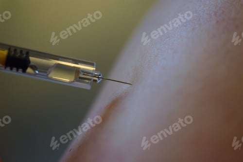 Preview: Selective focus shot of an injection into the arm