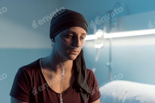 Preview: Sad young woman with cancer sitting on the hospital bed
