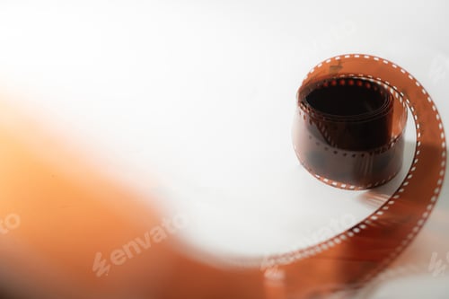 Preview: Curled Photographic Film Strip on Light Background