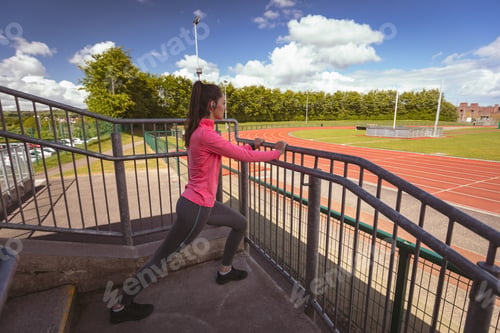 Preview: Woman performing stretching exercise in the stairs