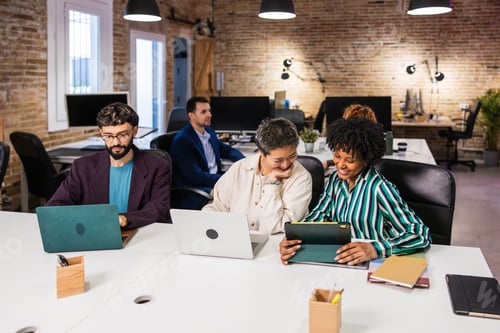 Preview: Multi ethnic team collaborating on project in modern office