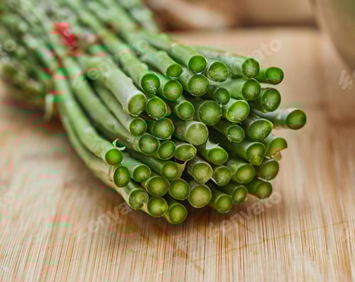 Preview: Asparagus lying on cutting board inbunch and ready to cook