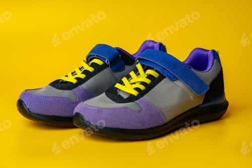 Preview: Violet-blue female sneakers on yellow studio background