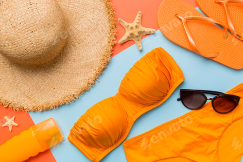 Preview: Woman swimwear and beach accessories flat lay top view on colored background