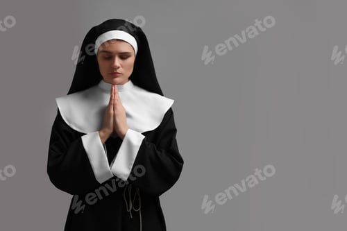 Preview: Nun with clasped hands praying to God on grey background. Space for text