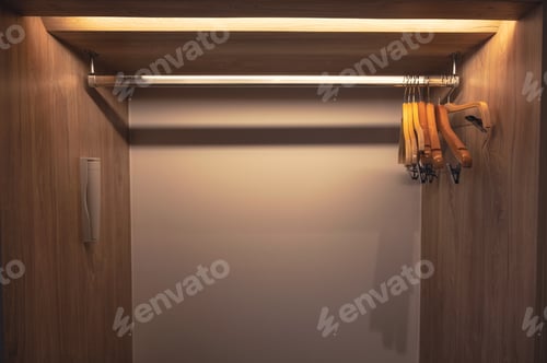 Preview: Row of empty clothes hanger on stainless rail in closet