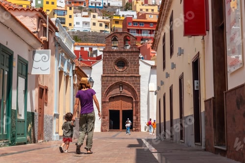 Preview: Vacation concept, mother with her son in her arms in the city of San Sebastian de la Gomera, Canary