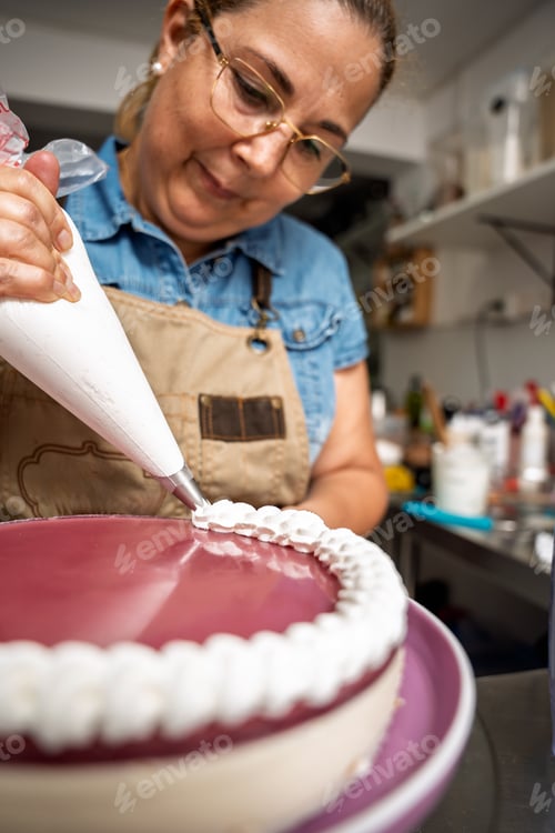 Visualização: Chef confeiteiro colocando chantilly em um bolo em uma cozinha comercial