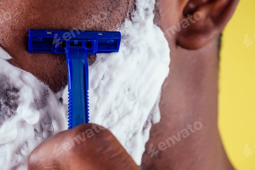 Preview: African-american man with razor and shaving foam on his face