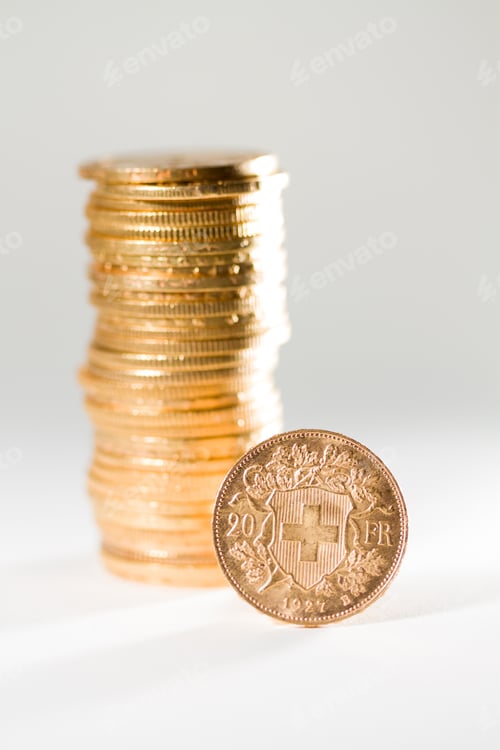 Preview: Swiss Gold Coins Stacked High on White Surface