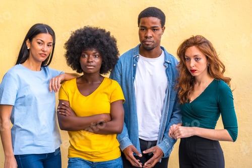 Preview: Group portrait young multi ethnic friends against yellow wall, international youth community people
