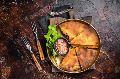 Preview: Traditional Ossetian pie sliced on a plate. Dark background. Top view