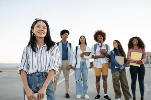Preview: portrait of a group of multiracial students looking at camera - focus on asian woman -