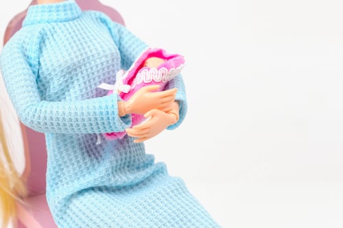 Preview: doll with a baby in her arms, creative concept of pregnancy and childbirth
