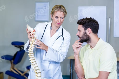 Preview: Physiotherapist explaining spine model to patient