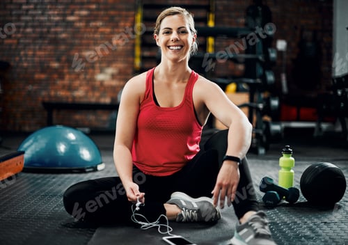 Preview: Full length portrait of an attractive young female sitting in the gym after a workout