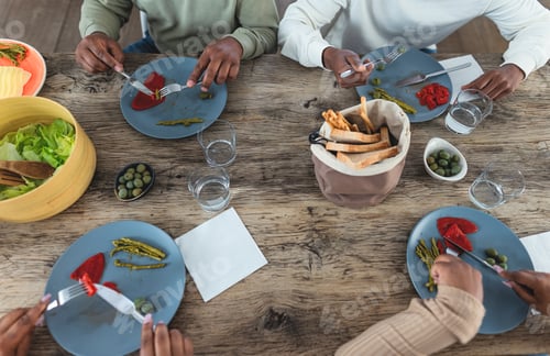 Preview: Top view of black family eating healthy lunch with fresh vegetables at home