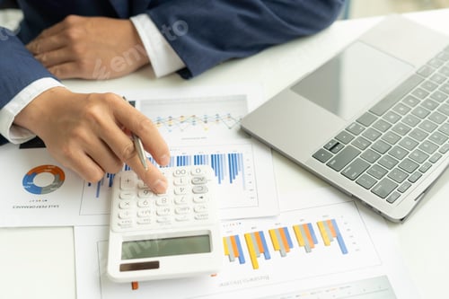 Preview: A close-up of an Asian male finance man's hand pressing a calculator on a desk in an office.