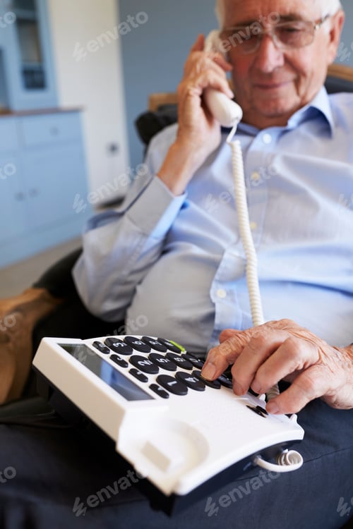 Preview: Senior Man At Home Using Telephone With Over Sized Keys