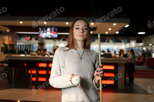 Preview: Woman with a cue in hands in a billiards club
