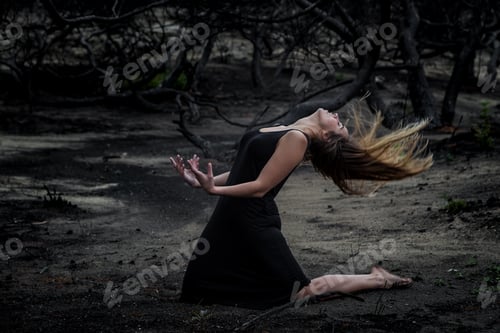 Preview: Woman posing on ground near dry trees