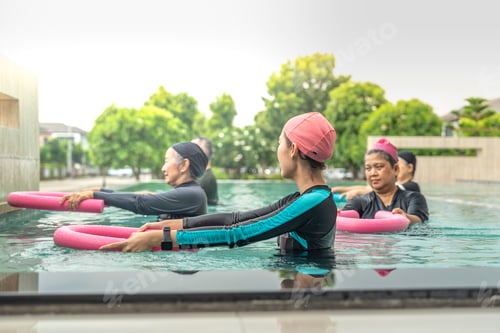 Vista previa: Una atractiva clase de ejercicios acuáticos para personas mayores dirigida por un instructor en una piscina.