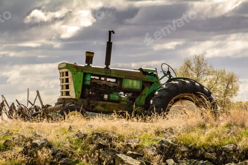 Preview: Slight closeup shot of a green vintage tractor in a grass field