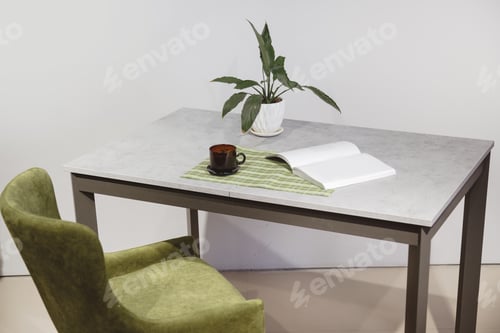 Preview: Modern minimalist workplace. Green velours armchair and loft table with home plant in white pot