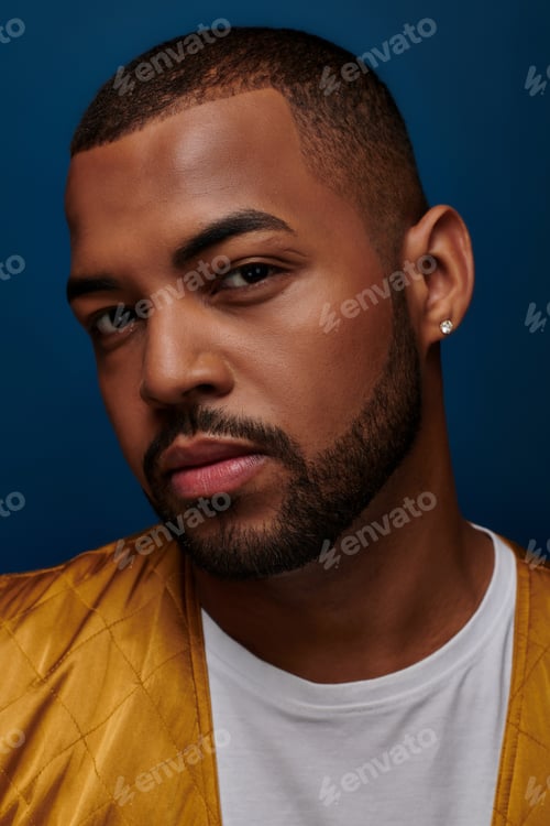 Preview: portrait of handsome stylish man with beard and diamond earring looking at camera, fashion concept