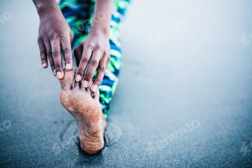 Preview: Close-up of Woman stretching her leg after workout on the beach