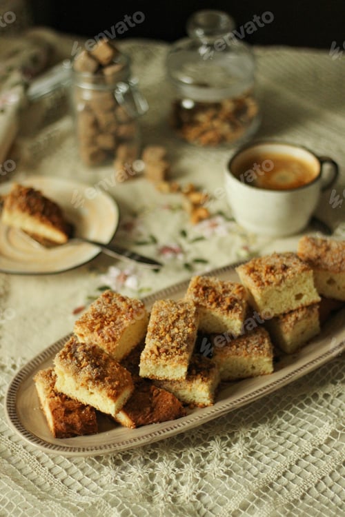 Preview: Cookies with nuts and sugar lie on a dish on the table next to a cup of coffee