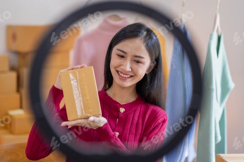 Preview: Asian women SME selling clothes online, She is answering customers' questions by phone and laptop