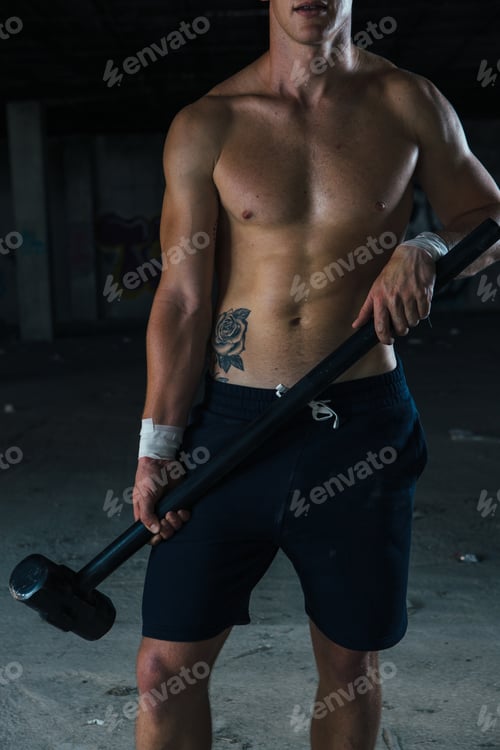 Preview: Faceless sportsman holding sledgehammer
