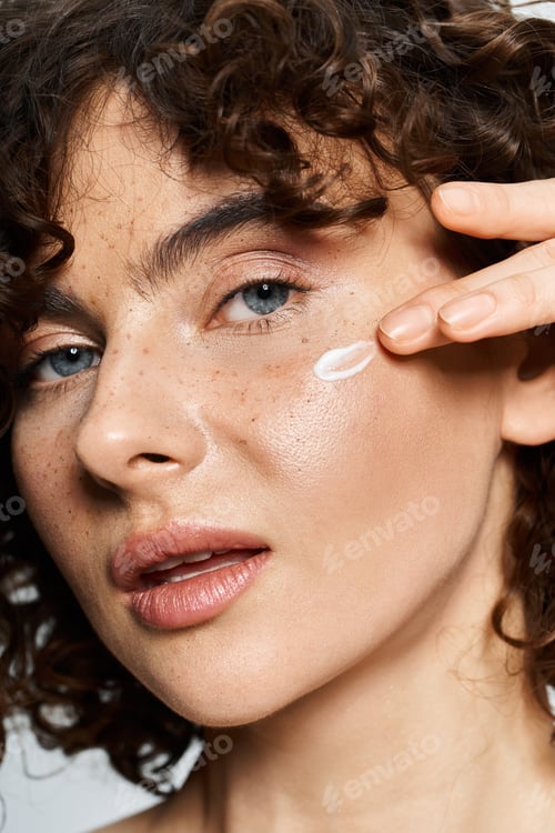 Preview: A young woman boosts her natural beauty with cream, radiating confidence.