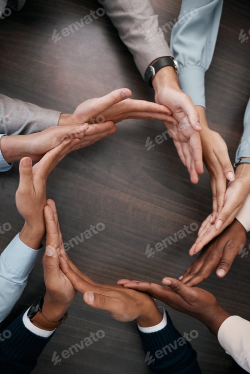 Preview: Hands, teamwork and synergy with business people in a circle or huddle as a team on a wooden table