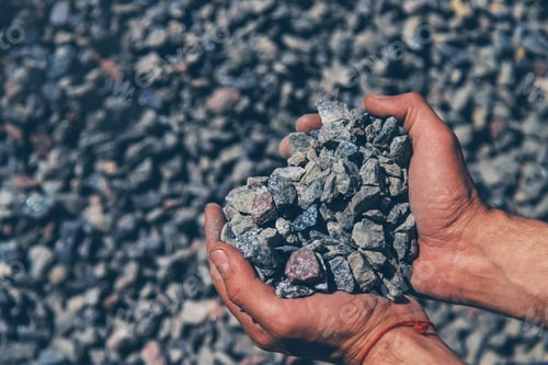 Preview: Crushed stones in the hands of a man. Selective focus.