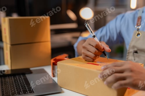 Preview: Asian man business owner selling online working overtime at night prepares to pack products