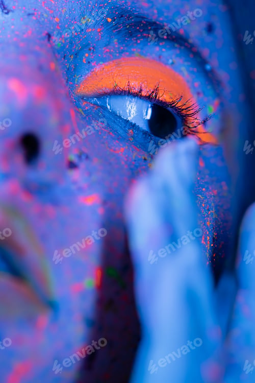 Preview: close up portrait of cropped woman with bright coral eye shadow and colorful paint spots in blue