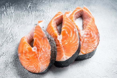 Preview: Salmon or trout steaks, raw fish prepared for cooking. White background. Top view