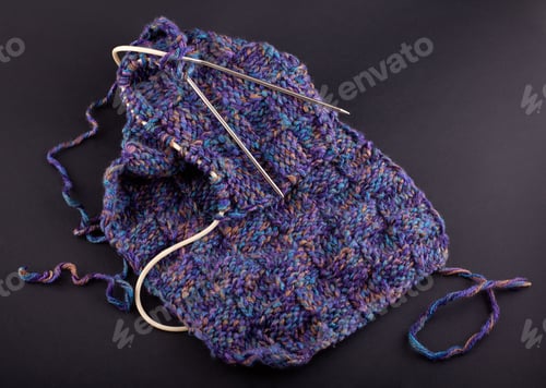 Preview: A Piece Of Purple Knitting, Against A Dark Background