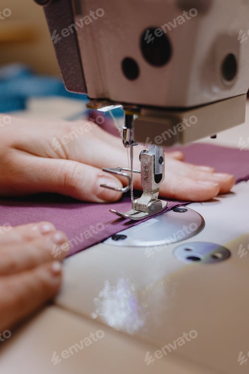Preview: woman sews piece of cloth on sewing machine. industrial metal machine for all fabric tops.