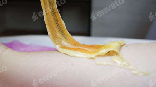 Preview: close-up of a master holding a sticky sugar paste in which the hair is stuck after removal