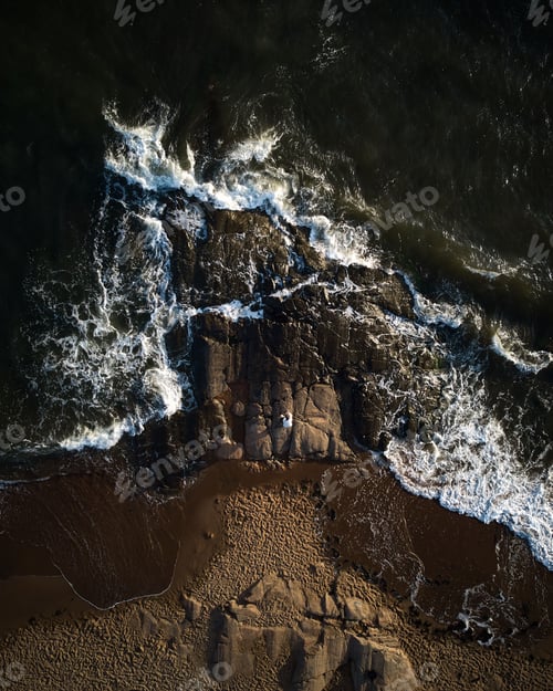 Preview: Scenic aerial shot of an ocean horizon with waves crashing onto the shoreline below.