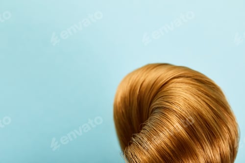 Preview: Close up view of twisted brown hair on blue background with copy space