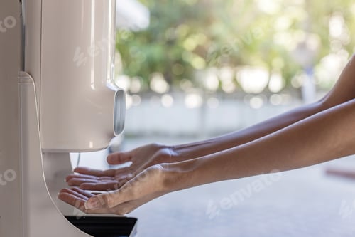 Preview: Hands under the automatic alcohol dispenser. Infection and hospitably concept.